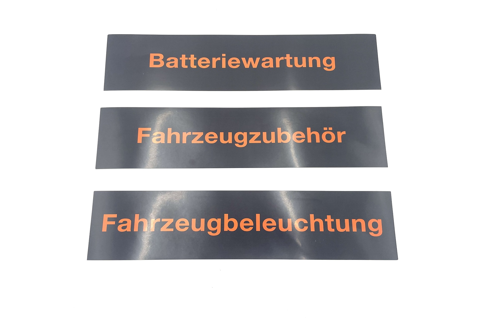 Magnetische Schilder mit den Aufschriften „Batteriewartung“, „Fahrzeugzubehör“ und „Fahrzeugbeleuchtung“ für die flexible Kennzeichnung von Regalen oder Arbeitsbereichen.